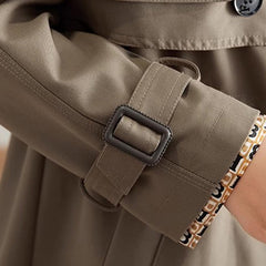 Damski zwężany trencz o długości midi z klapami